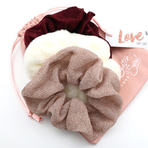Set of three scrunchies in brown, white, and red on a pink heart-shaped box with 'Love' text.