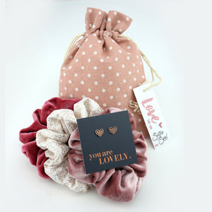 Set of scrunchies with a card and a polka dot drawstring bag on a white background