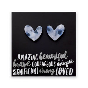 A square black art print or card featuring two marbled heart shapes above stylized white text reading 'AMAZING beautiful brave COURAGEOUS unique SIGNIFICANT strong LOVED'.