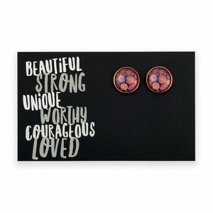 Pair of round earrings on a black card with motivational text