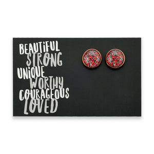 Round earrings with a red and black pattern on a card with motivational text.