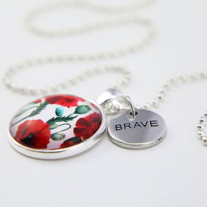 Necklace with floral pendant and 'BRAVE' charm on a white background
