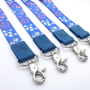 Set of blue floral dog leashes with silver hooks on a white background