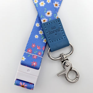 Floral lanyard with blue strap and 'so loved' tag on a white background