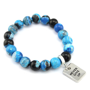 Blue and black beaded bracelet with a silver 'Never Give Up' charm on a white background