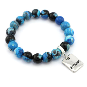 Blue and black beaded bracelet with a 'STRONG' charm on a white background