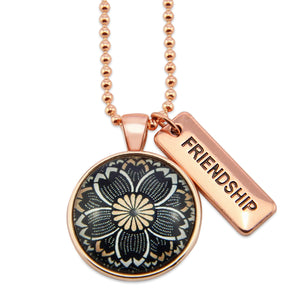 Necklace with floral pendant and 'Friendship' tag on a white background
