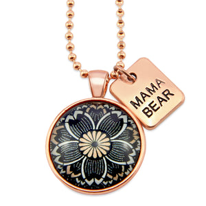 Necklace with floral pendant and 'Mama Bear' tag on a white background