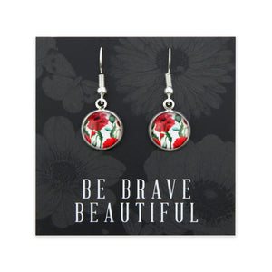 Earrings with floral design on a card with 'Be Brave Beautiful' text, black floral background