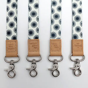 Four lanyards with star pattern and leather tags on a white background