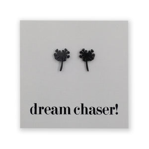 Black dandelion earrings on grey card.
