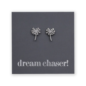 Silver dandelion-shaped earrings on a dark gray card with 'dream chaser!' text.