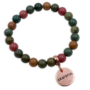 Multicolored beaded bracelet with a 'GRATEFUL' charm on a white background