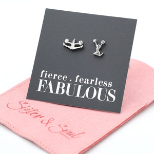 Cheer leader shaped Silver earrings on a card with 'fierce fearless FABULOUS' text, placed on a pink cloth.