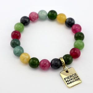 Multicolored beaded bracelet with a gold charm on a white background
