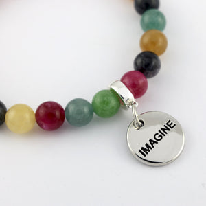 Multicolored beaded bracelet with a silver 'IMAGINE' charm on a white background