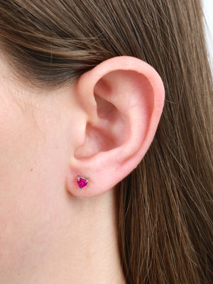Pink heart earring in girls ear.