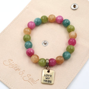 Colorful beaded bracelet with 'Love My Tribe' charm on a beige card, featuring the brand 'Sister & Soul'.
