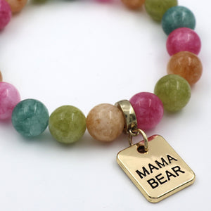 Multicolored beaded bracelet with a gold 'MAMA BEAR' charm on a white background