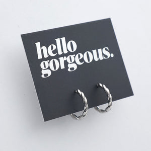 Silver twisty hoops on a grey card that has silver writing saying "Hello Gorgeous" on a white background