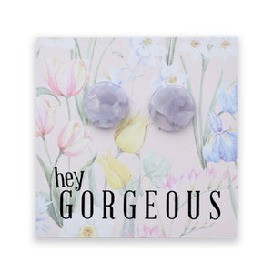 A pair of round, faceted lavender gemstone stud earrings displayed on a square floral backing card with the text 'hey GORGEOUS'.