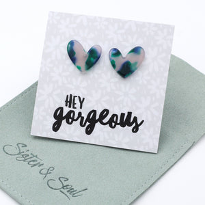 Heart-shaped earrings on a card with 'hey gorgeous' text on a sage pouch