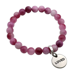 Pink beaded bracelet with a 'LOVED' charm on a white background