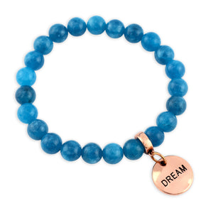 Blue beaded bracelet with a rose gold charm labeled 'DREAM' on a white background