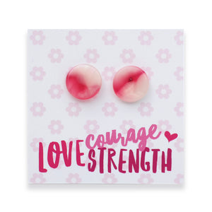 A pair of round resin stud earrings with a pink and white marbled pattern, displayed on a white card with a pink floral pattern and the words 'courage LOVE STRENGTH' in pink text.