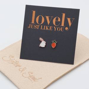 A pair of sterling silver stud earrings with one designed as a bunny and the other as a carrot, presented on a card with 'lovely just like you' printed in rose gold lettering. Showing gift pouch.
