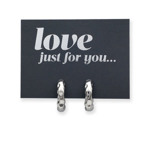 Silver Huggies hoop earrings on a grey card with silver wording that says "love just for you" on a white background