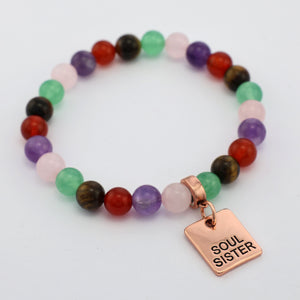 Multicolored beaded bracelet with a 'Soul Sister' charm on a white background