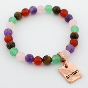 Colorful beaded bracelet with a 'STRONG' charm on a white background