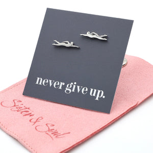 Silver diving or swimming earring on a 'never give up' card with pink jewelry pouch