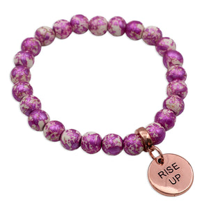 Purple beaded bracelet with a rose gold charm labeled 'Rise Up' on a white background