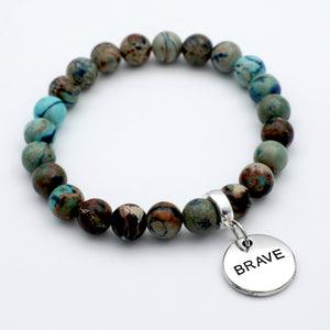 Beaded bracelet with a 'BRAVE' charm on a white background