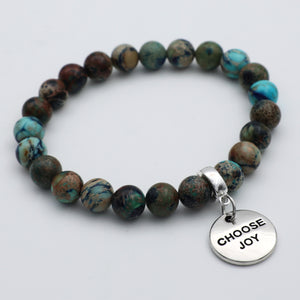 Beaded bracelet with a 'CHOOSE JOY' charm on a light gray background