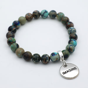 Beaded bracelet with 'IMAGINE' charm on a white background