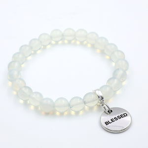 White beaded bracelet with a 'BLESSED' charm on a white background