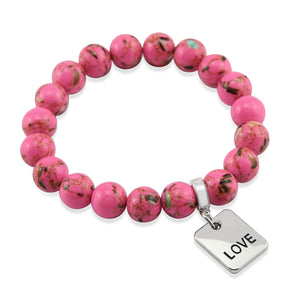 Pink beaded bracelet with a silver 'LOVE' tag charm on a white background