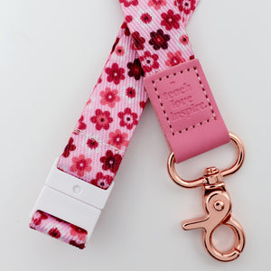 Floral lanyard with pink keychain and 'touch love inspire' tag on a white background