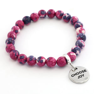 Pink and purple beaded bracelet with a 'Choose Joy' charm on a white background