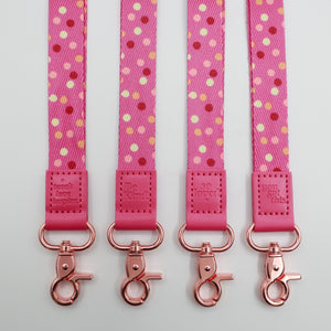 Pink Polka lanyards showing Be Kind, Teach Love Inspire, You Got This and So Loved embossed trims and lobster clasps.