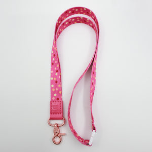Teach Love Inspire embossed on a pink polka dot lanyard with pink trim and a lobster clasp.