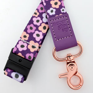 Floral patterned lanyard with purple accent and rose gold clasp on a white background