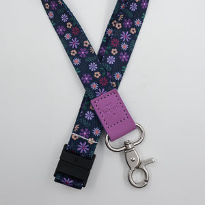 So Loved embossed on a navy floral lanyard with purple trim and a lobster clasp.