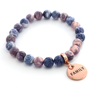 Beaded bracelet with a 'FAMILY' charm on a white background