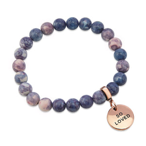Two bracelets with purple and storm patch agate stone beads and rose gold word charms, one with 'INSPIRE' and the other with 'WARRIOR'.