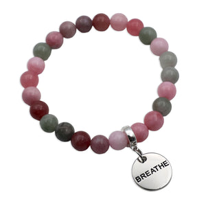 Multicolored beaded bracelet with a 'BREATHE' charm on a white background