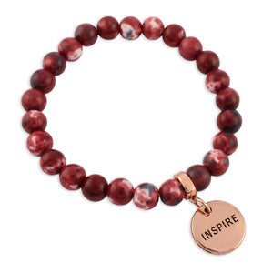 Beaded bracelet with a 'Inspire' charm on a white background